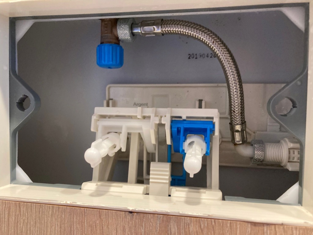 Toilet cistern interior showing blue isolation knob